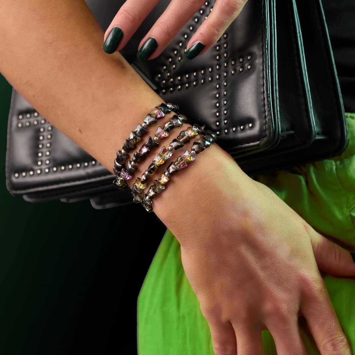 Midnight Flutter butterfly wrap bracelet with black and amber hand-strung beads on clear elastic worn layered on wrist by NOGU